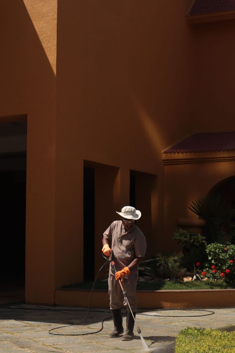 Pressure washing a stone walkway outside a building