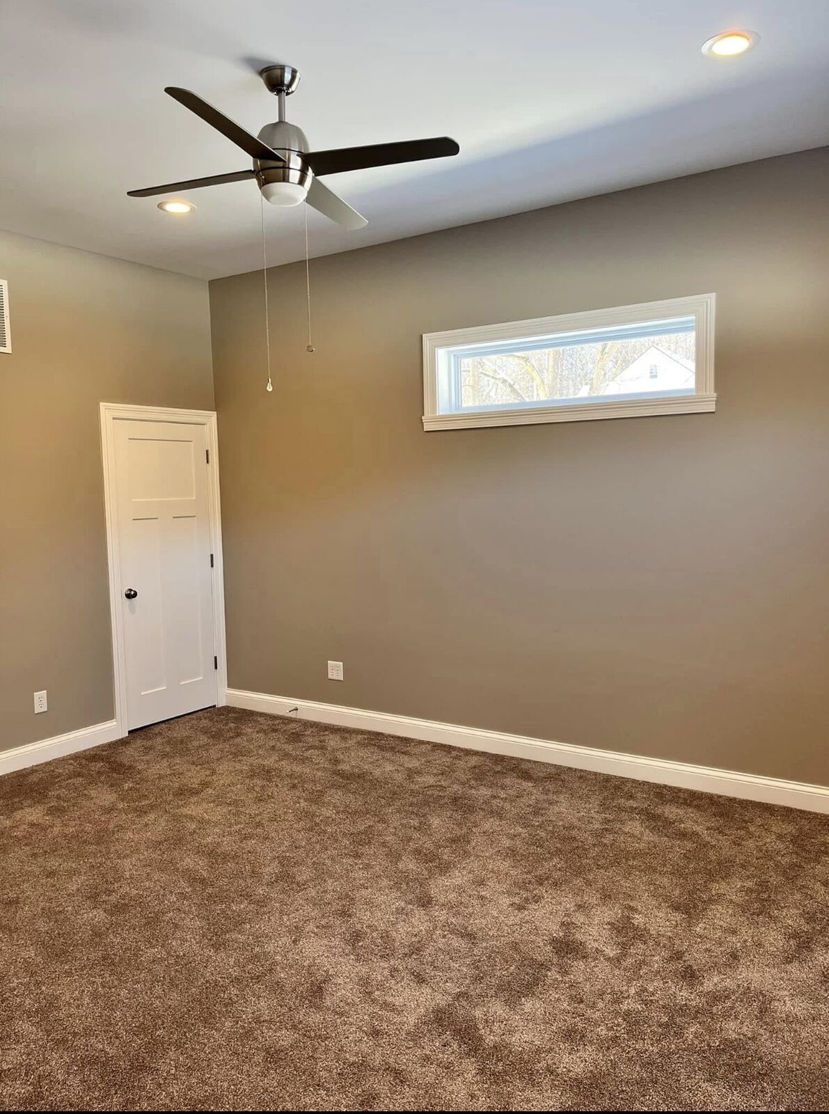 Bedroom painted a warm greige with white trim and doors