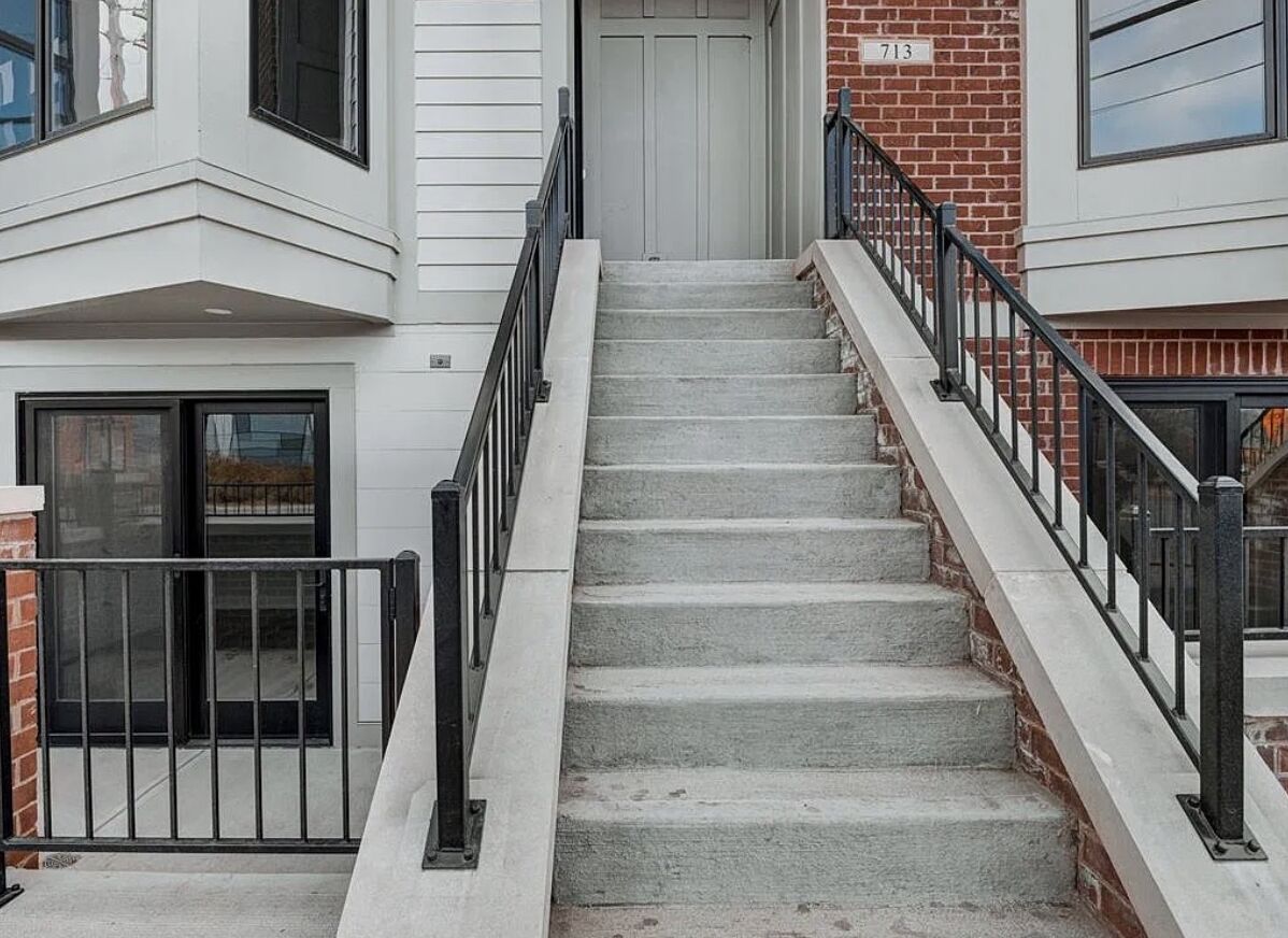 Exterior stairs and painted siding at a modern townhome