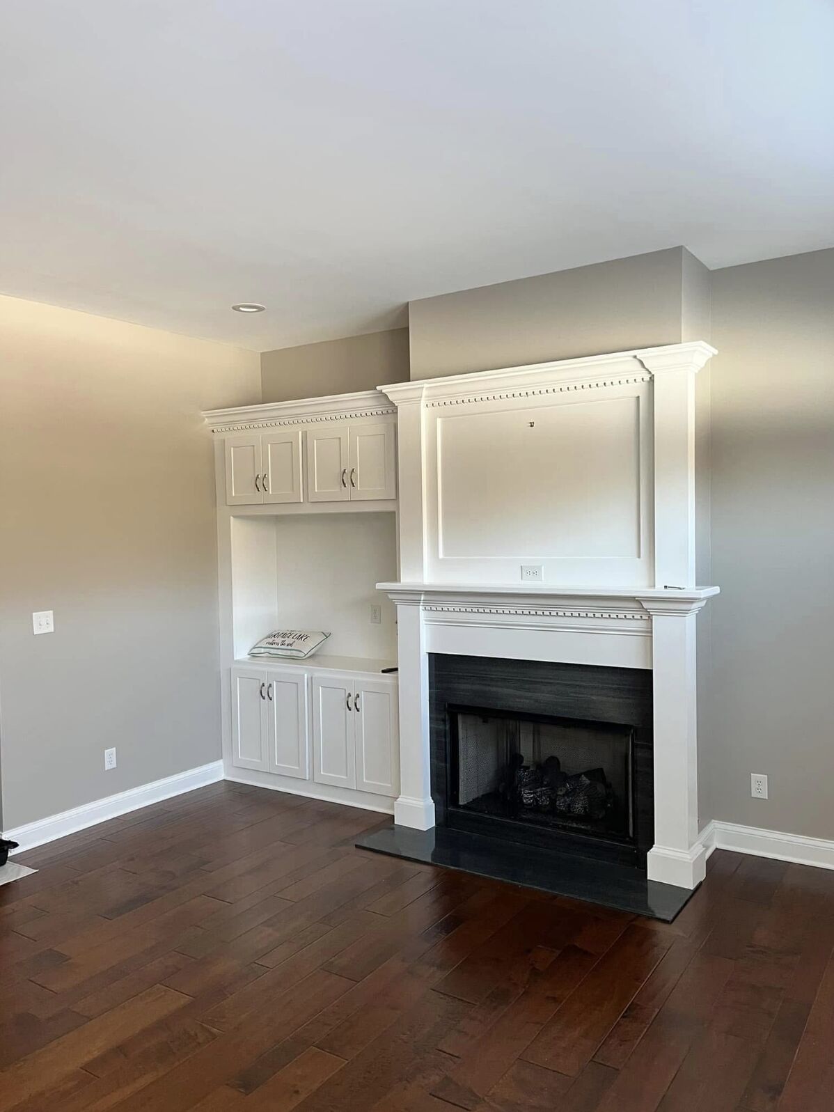 Painted fireplace mantel and white built-in cabinets
