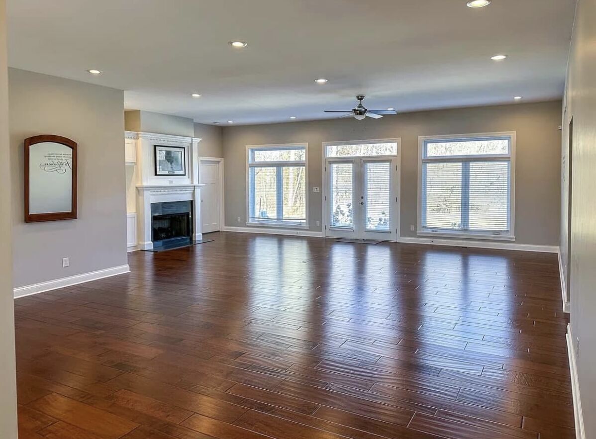 Freshly painted great room with hardwood floors, fireplace and a wall of windows