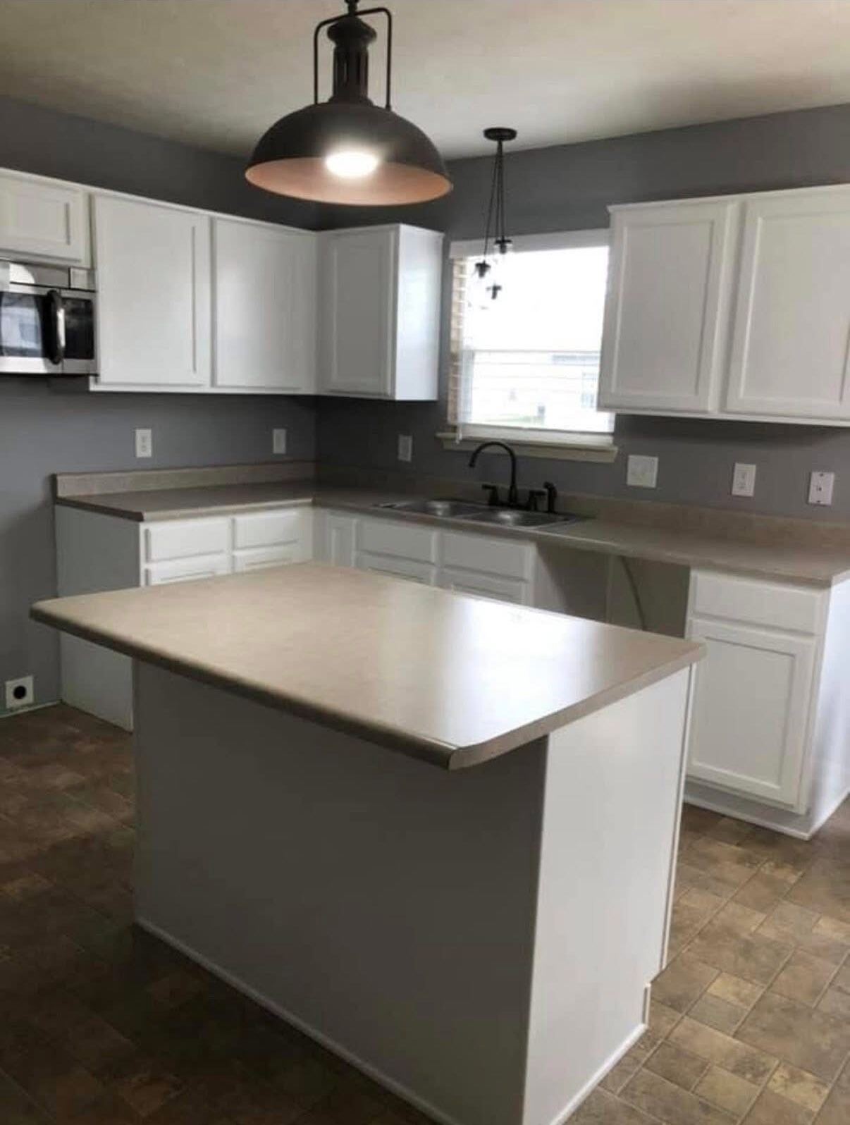Kitchen with white painted cabinets, gray walls and a center island