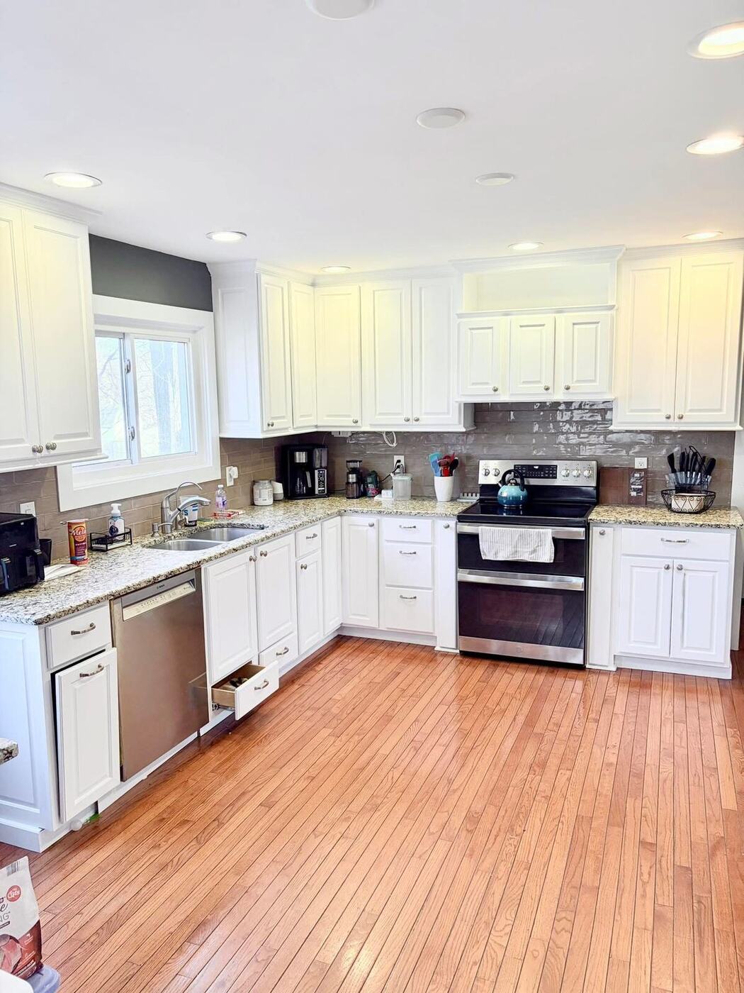 Bright kitchen with white painted cabinets and hardwood floors