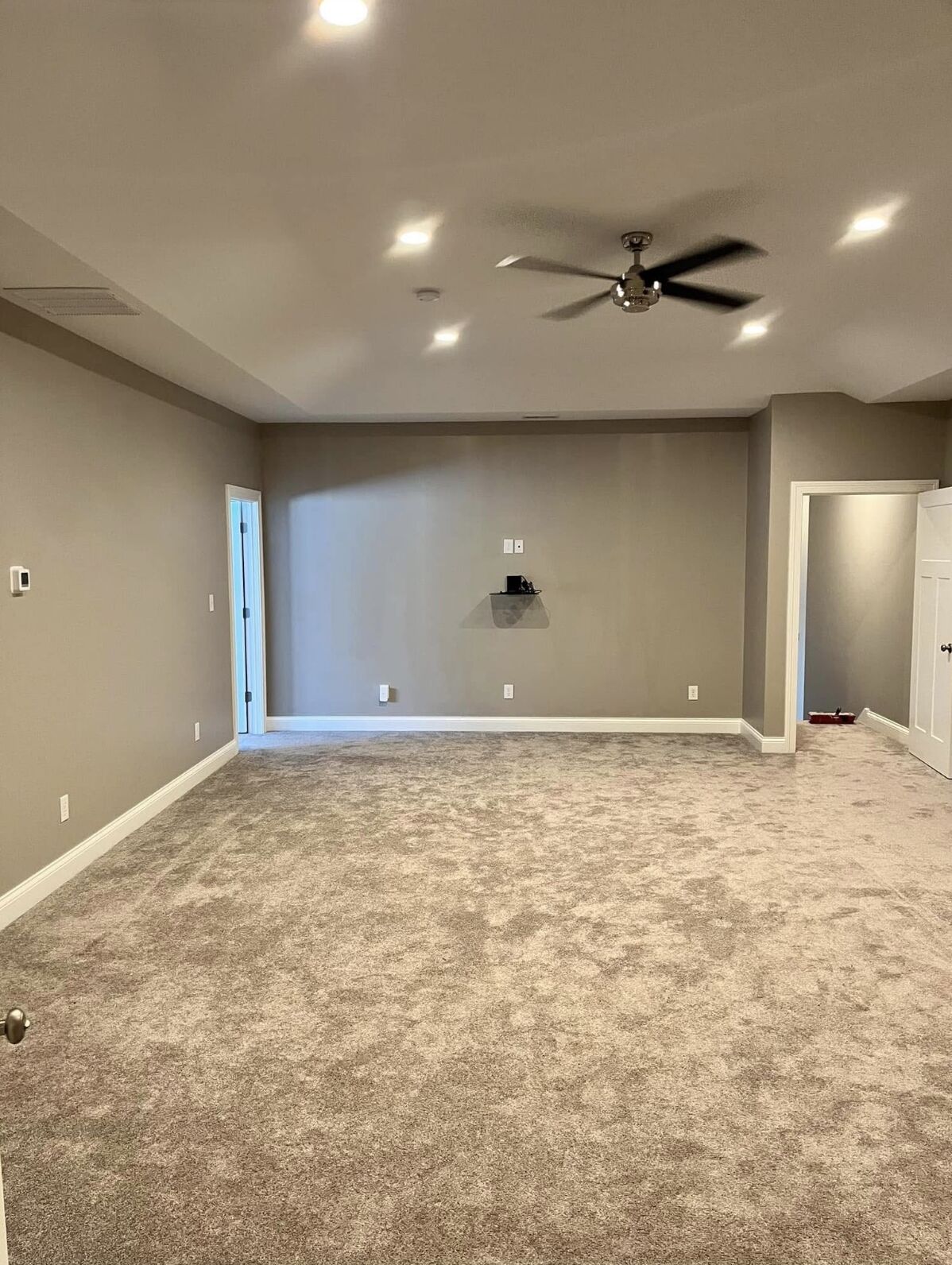 Lower-level living space with fresh gray walls and recessed lighting