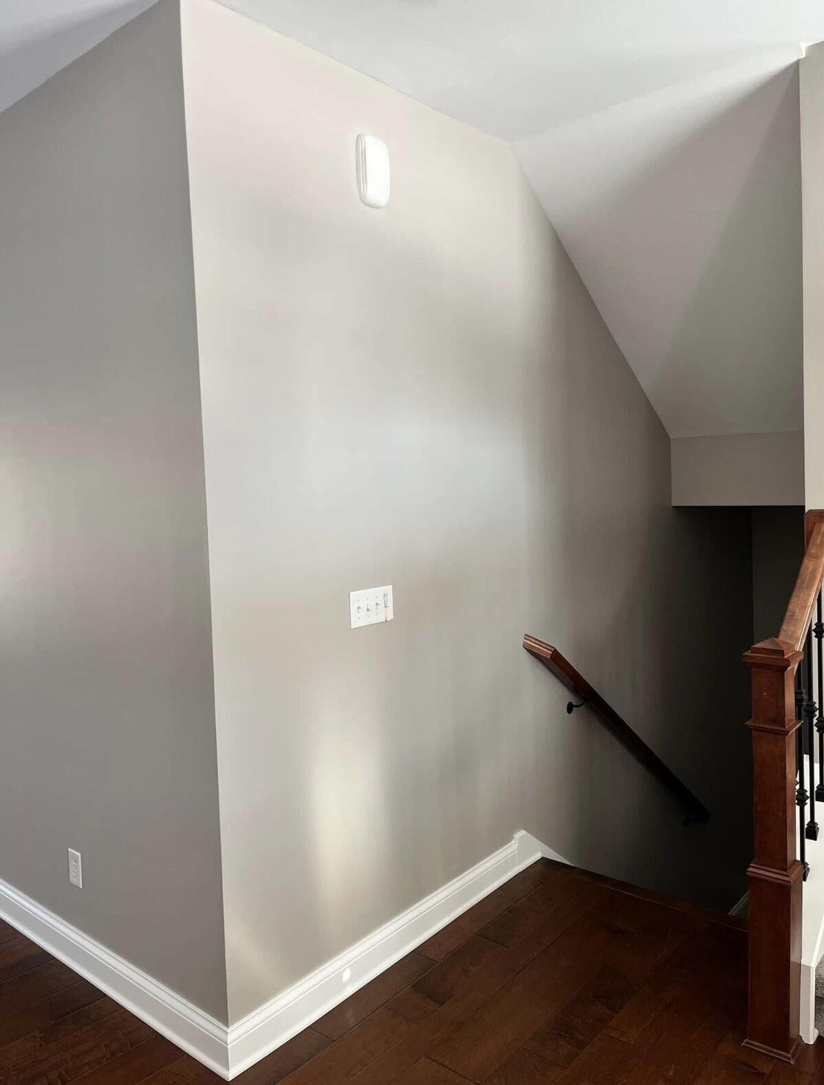 Stairwell walls painted in a soft neutral with white baseboards