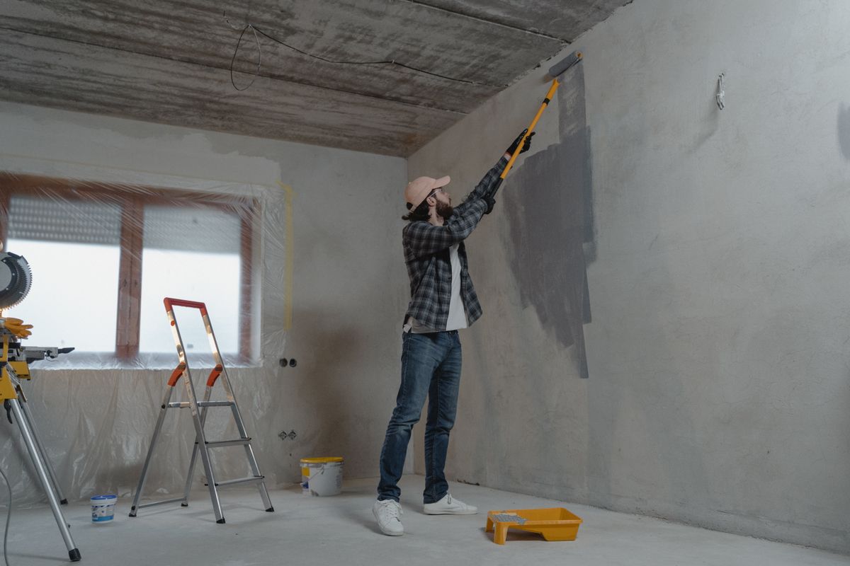 Painter rolling paint onto an interior wall
